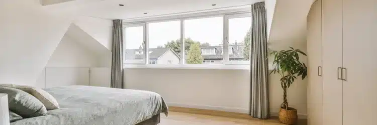 Lichte zolder-slaapkamer onder een brede dakkapel met bed, kast en veel daglicht