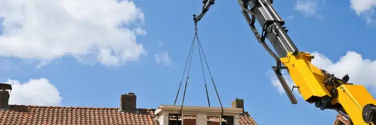 Prefab dakkapel wordt met een kraan op het schuin dak gezet