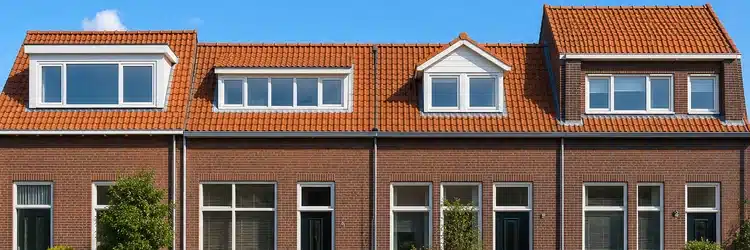 Verschillende dakkapelvormen op rijtjeswoningen: plat dak, puntdak en verhoogde nok naast elkaar